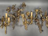 six antique brass wall sconces with candles and a candle holder