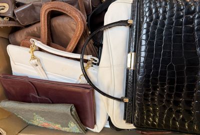 a box full of purses and other handbags sitting on the floor
