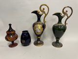 trois vases et un vase posés sur une table, sur fond blanc