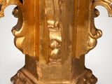 an image of a gold statue of a man holding a cross