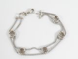 a close up of a silver bracelet on a white surface