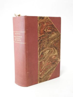 an old book sitting on top of a white table next to a white wall