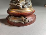 a statue of a dog sitting on top of a wooden base