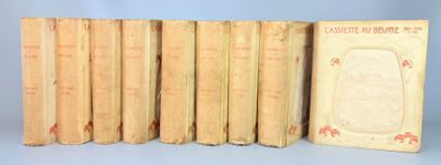 several old books are lined up in a row on a blue surface