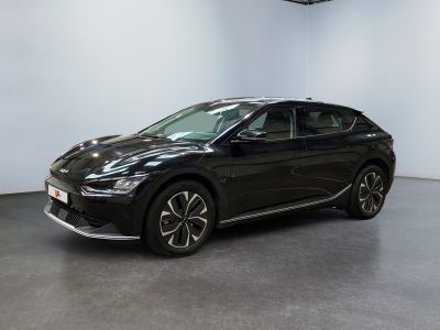 the black car is parked in a large room with a white wall