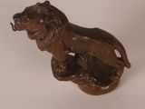 bronze statue of a lion on a rock with a chain around its neck
