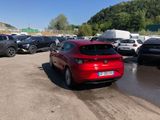 a red car parked in a parking lot next to other cars