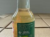 a bottle of apple cid sitting on a tile floor
