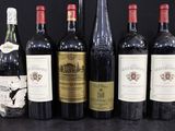 Plusieurs bouteilles de vin sont alignées sur une surface noire