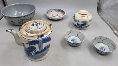 une table sur laquelle se trouvent une théière, des bols et des tasses