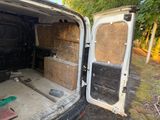 a van that has been vandalized and is parked in the woods