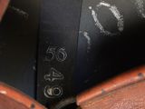 a close up of a brown leather bag with a tag on it