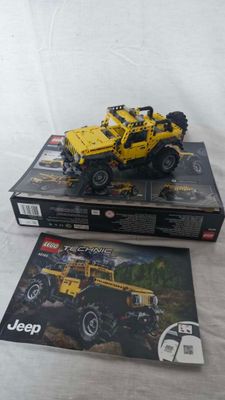 two boxes of lego jeeps on a white surface with a white background