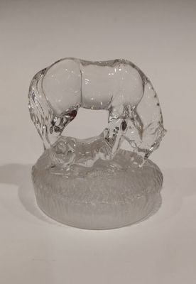 une figurine en verre représentant un cheval posée sur un socle