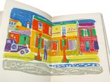 an open book with a picture of a city on it