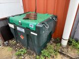a large green box sitting on the ground next to a building