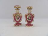 pair of pink and gold vases with flowers on them on a white surface