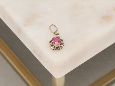 silver and pink earrings on a marble table with a gold frame