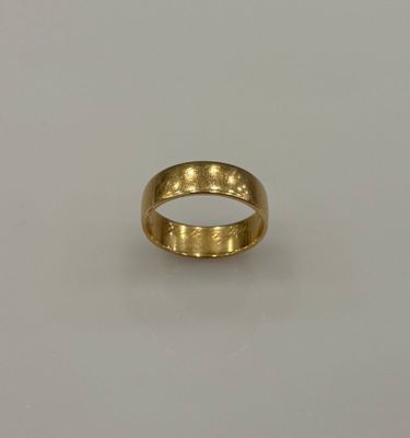 gros plan d'une bague en or sur une surface blanche