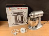 a silver kitchen aid mixer on a table next to a box