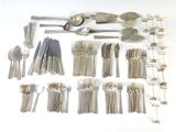 many different types of silverware and spoons laid out on the table