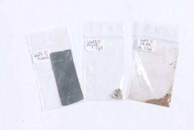 three bags of sand and a piece of metal on a table