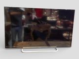 un homme debout devant un téléviseur à écran plat