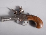 an old gun with a wooden handle on a white surface