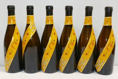 six bouteilles de vin sont alignées sur une table