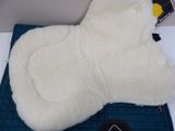 a white sheepskin mitt on top of a blue pad