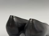 a close up of a pair of black shoes on a white surface