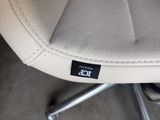 a close up of a white leather chair with a black sticker on it