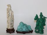 trois figurines assises l'une à côté de l'autre