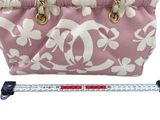 pink and white floral purse with gold handles and a measuring tape