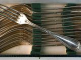 a lot of forks and spoons in a box