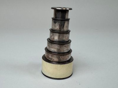 une pile de vases en bois posée sur une surface blanche