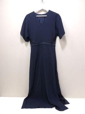 La robe est suspendue à un cintre contre un mur blanc.