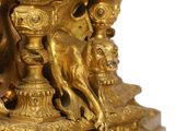 a gold clock with a bird on top of it