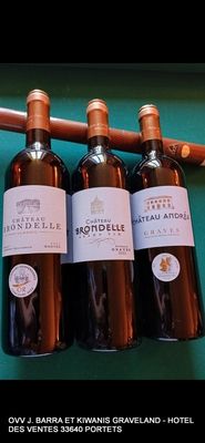 quatre bouteilles de vin sont alignées sur une table de billard