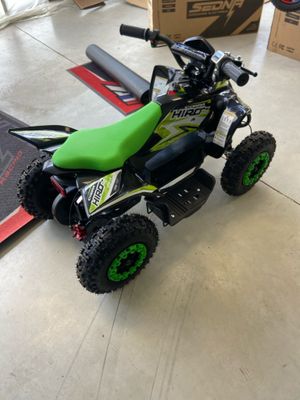 une photo d'une moto tout-terrain verte et noire dans un garage