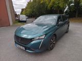 La voiture bleue est garée sur le parking, à côté d'un immeuble.