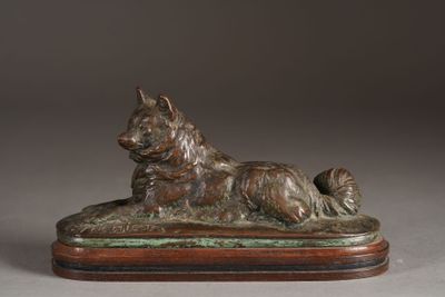 statue of a dog laying on a wooden base on a gray background