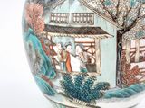 a vase with a painting on it sitting on a table