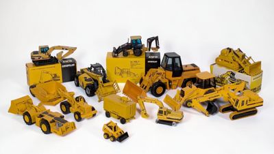de nombreux engins de chantier miniatures posés sur une surface blanche