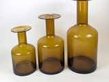 three brown glass vases sitting next to each other on a white surface