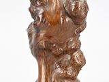 sculpture marron représentant un chien dont la tête repose sur une souche d'arbre