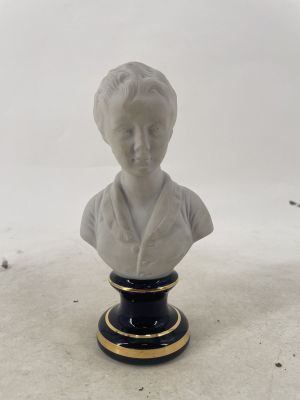 statue of a woman in a white dress on a black and gold pedestal
