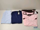 Trois t-shirts sont posés les uns à côté des autres sur une table.