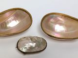 a close up of three pieces of jewelry on a white surface