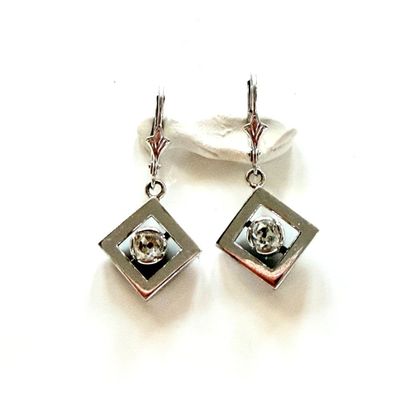 une paire de boucles d'oreilles en argent et cristal sur fond blanc